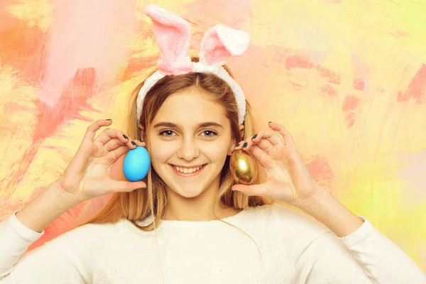 Feliz chica de Pascua en orejas de conejo con oro, huevos azules —  Fotos de Stock