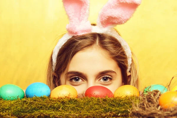 Menina feliz Páscoa em orelhas de coelho com ovos coloridos, musgo — Fotografia de Stock