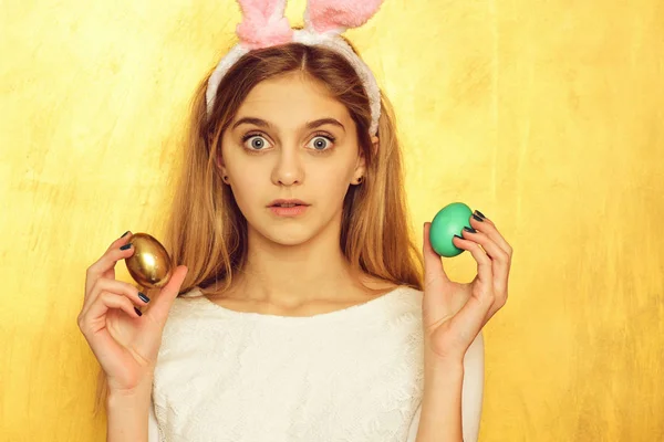 Menina feliz Páscoa em orelhas de coelho com ovo dourado — Fotografia de Stock