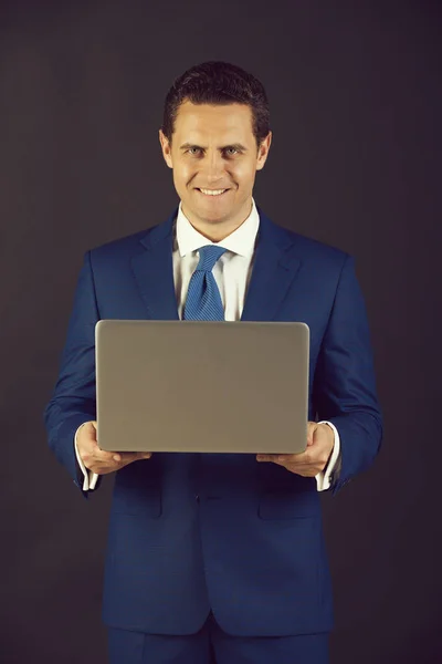 Бизнесмен улыбается с ноутбуком — стоковое фото