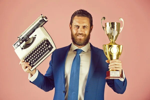 happy business man with typewriter and golden champion cup