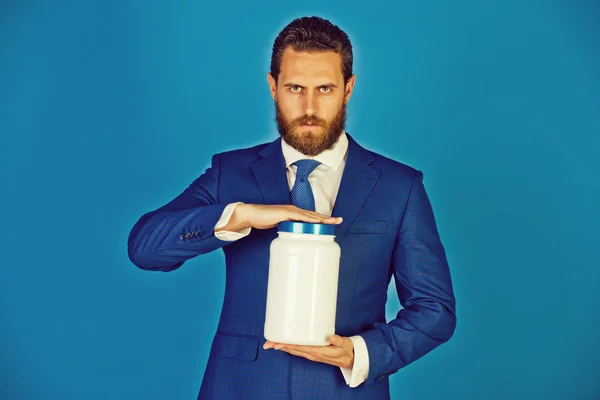 Hombre o hombre de negocios barbudo con frasco de plástico sobre fondo azul — Foto de Stock