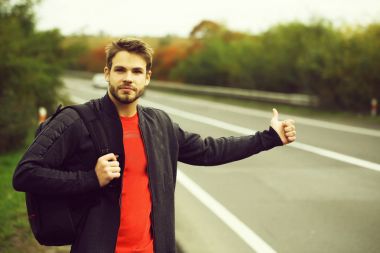 Genç adam otostop çekiyor.