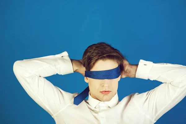 tie on face and eyes of young blindfolded man, businessman