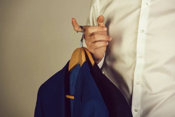 Hanger met formele jas in de hand van de mens in shirt — Stockfoto