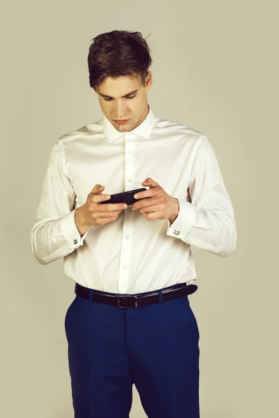 Mies valkoisessa paidassa, siniset housut kalvosinnapilla käytä puhelinta — kuvapankkivalokuva