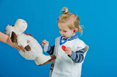 Çocuk tedavi oyuncak koyun aşı üzerinde mavi arka plan ile