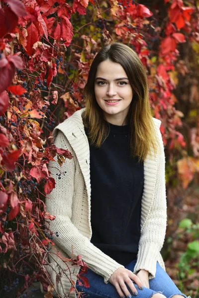 Dívka s usmívající se tvář s červenými listy na pozadí, podzim — Stock fotografie