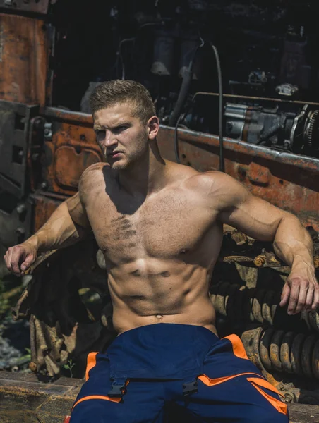 Sexy man met naakte torso rust in de buurt van Bouwmachines — Stockfoto