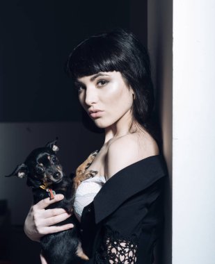 Küçük köpek ya da köpek yavrusu kadın gizemli yüz tutan.