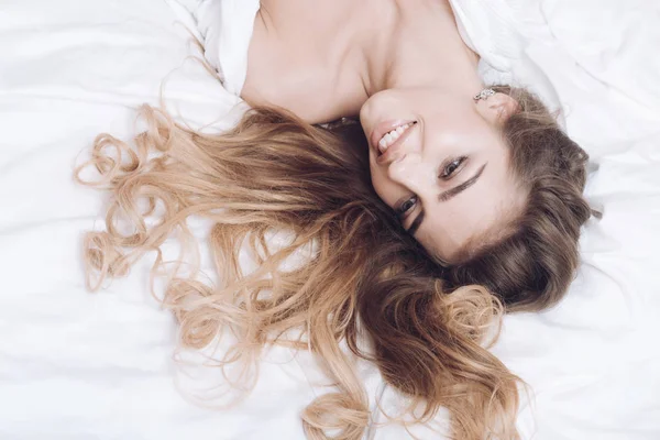 Concepto de bienestar de lujo. Señora con maquillaje relajante en la cama . — Foto de Stock