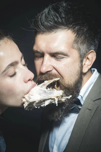 Mann und Frau mit Hühnerskelett im Mund, schwarzer Hintergrund. — Stockfoto