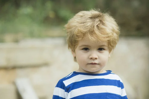 Child or boy with calm face wears striped clothes. — Stock Photo, Image