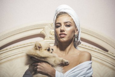 Bayan bornoz dalgın yüzüne ile yatakta oturur