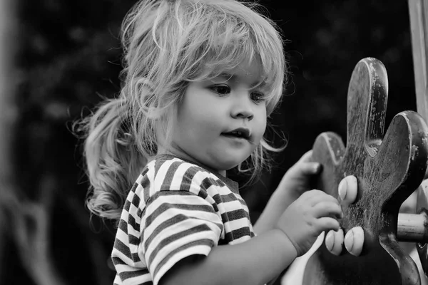 Bonito menino brinca no parque infantil — Fotografia de Stock