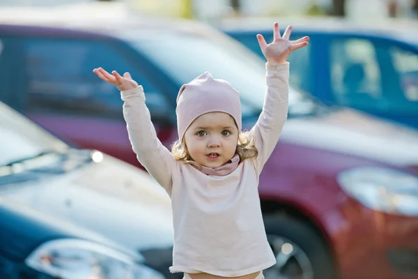 Menina com as mãos levantadas stand no parque de estacionamento — Fotografia de Stock