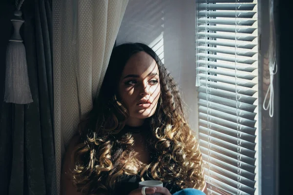 Menina na janela com xícara de chá ou café — Fotografia de Stock