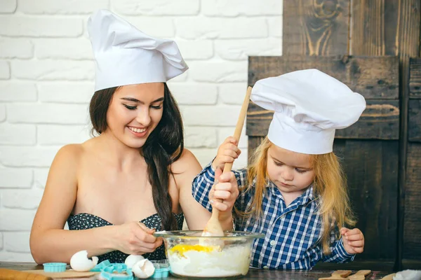 Mujer y niño niño en sombreros de chef con cuchara — Foto de Stock