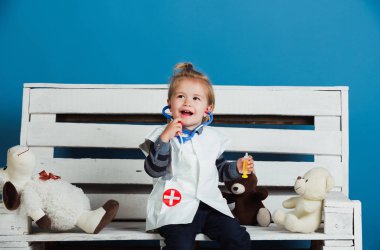 Evcil hayvan tahta bankta oturmak oyuncak ile mutlu bebek