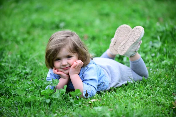 Kleines Mädchen ruht auf Gras — Stockfoto