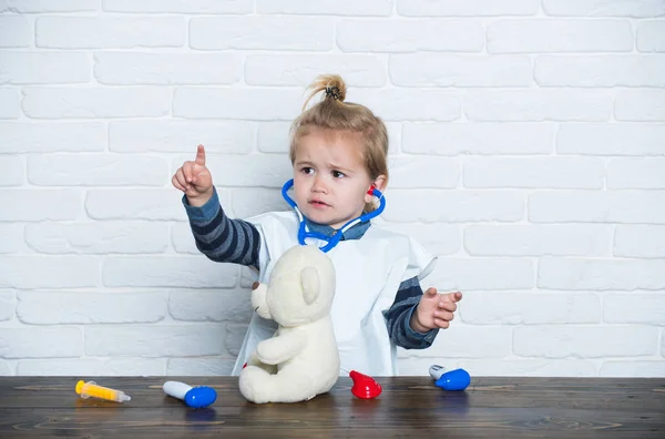 Menino veterinário médico com brinquedo ursinho dedo indicador — Fotografia de Stock