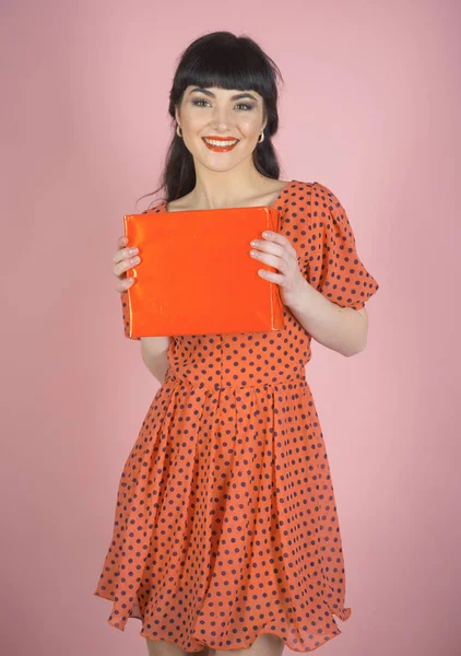 Attractive woman with makeup holds red box or gift.