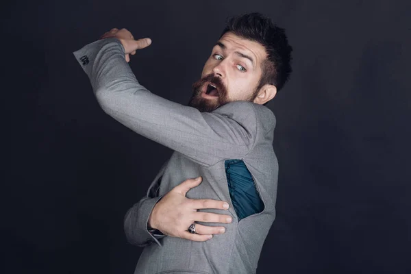 Hombre con barba lleva chaqueta con agujero sobre fondo oscuro . — Foto de Stock