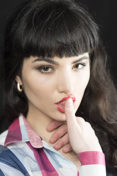 ブルネットの髪でセクシーな女性が赤い唇に近い指を保持します。. — ストック写真