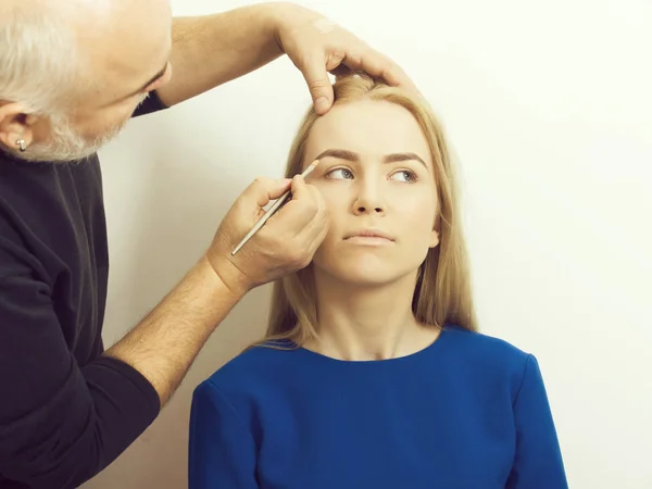 Visagiste aplicando maquillaje en la cara de chica — Foto de Stock