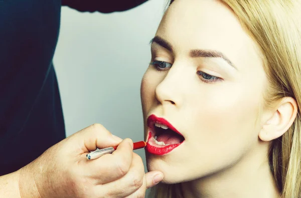 Mână aplicarea creionului roșu pe buzele femeii — Fotografie, imagine de stoc
