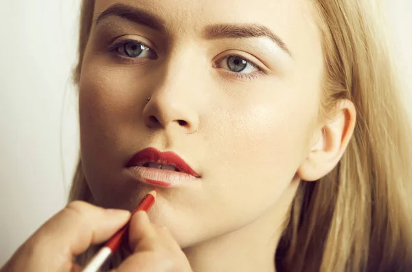 Meisje rood potlood op lippen krijgen door mannenhand — Stockfoto