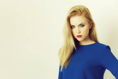 Mavi elbiseli poz yüzündeki kırmızı dudaklı kadın