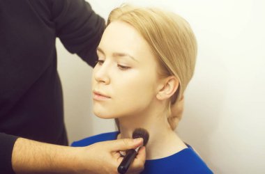 Kızın boynunda toz uygulama makyaj fırça ile erkek el