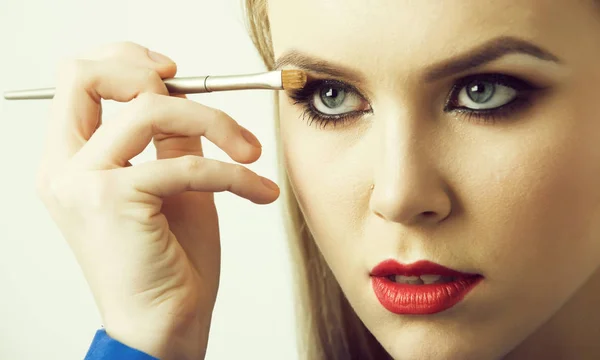 Wanita menerapkan eyeshadow pada mata dengan kuas makeup — Stok Foto