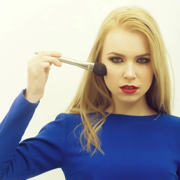 Kvinna applicera pulver på ansiktsvård med makeup borste — Stockfoto