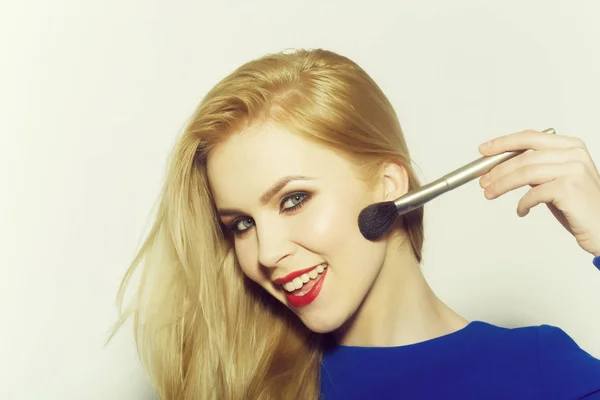 Mulher feliz aplicando maquiagem no rosto com escova de pó — Fotografia de Stock
