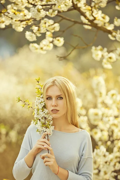 Mooie jonge vrouw in de bloeiende lentetuin — Stockfoto