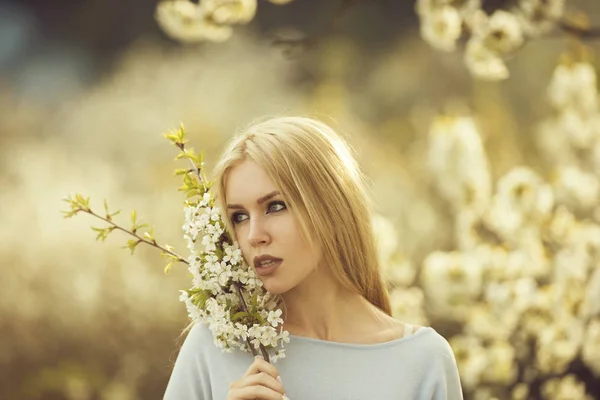 Meisje houden takken van wit, bloemen bloeien — Stockfoto