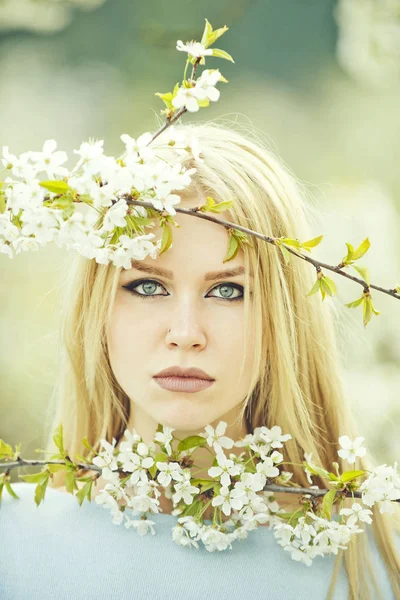 Frau mit blauen Augen posiert mit weißen, blühenden Blumen — Stockfoto