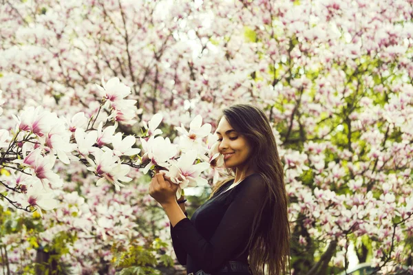 Outdoor portrait of a young beautiful woman near magnolia tree — Stock Photo, Image
