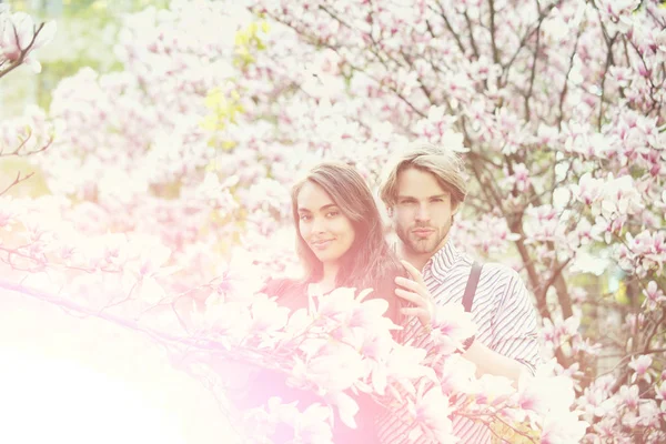 Ζευγάρι στην αγάπη, ο άνθρωπος και κορίτσι απολαμβάνοντας magnolia άνθος λουλούδι — Φωτογραφία Αρχείου