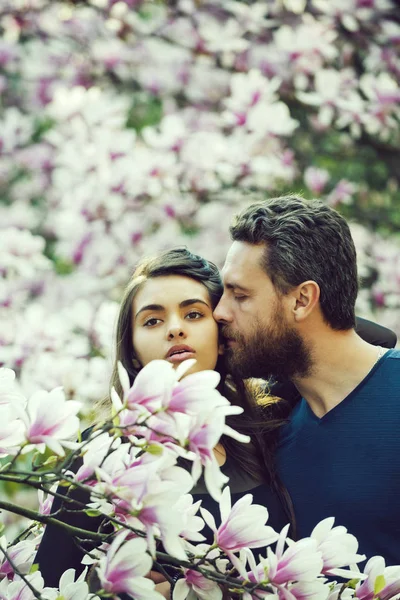 Couple amoureux, homme embrassant femme aux arbres fleuris, magnolia — Photo