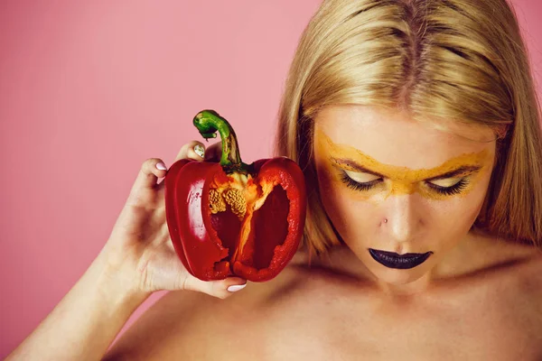 Paprika i handen av kvinna med kreativa fashionabla makeup — Stockfoto