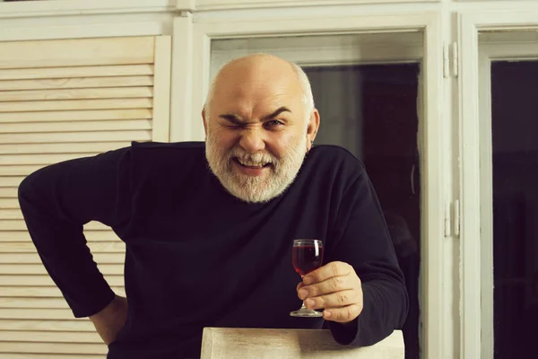 Man winking with glass of wine