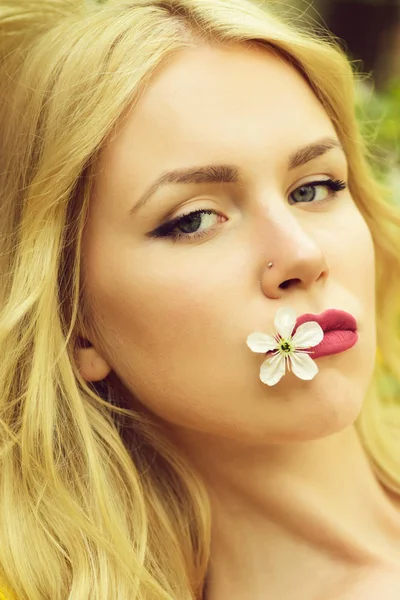 Ung flicka håller i munnen en vit cherry blomma — Stockfoto