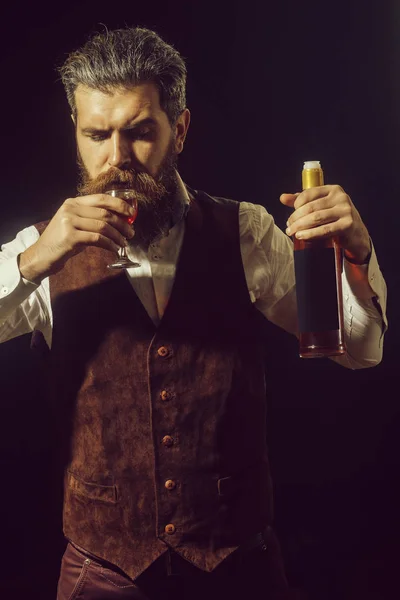 Homem com garrafa bebendo copo de vinho tinto — Fotografia de Stock