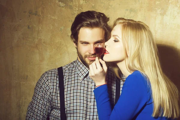 Man and girl posing with glass of red liqueur