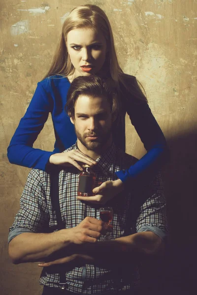 Žena s lahví objímání muž s likér — Stock fotografie