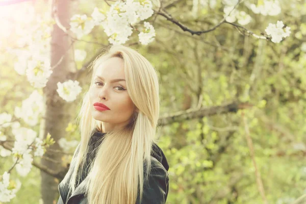 Söt flicka med röda läppar och blonda hår i blossom — Stockfoto