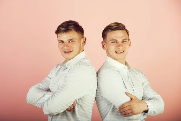 Dos hermanos sonriendo sobre fondo rosa — Foto de Stock